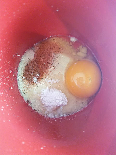 Egg, flour, baking powder, and seasoning inside of coffee mug.